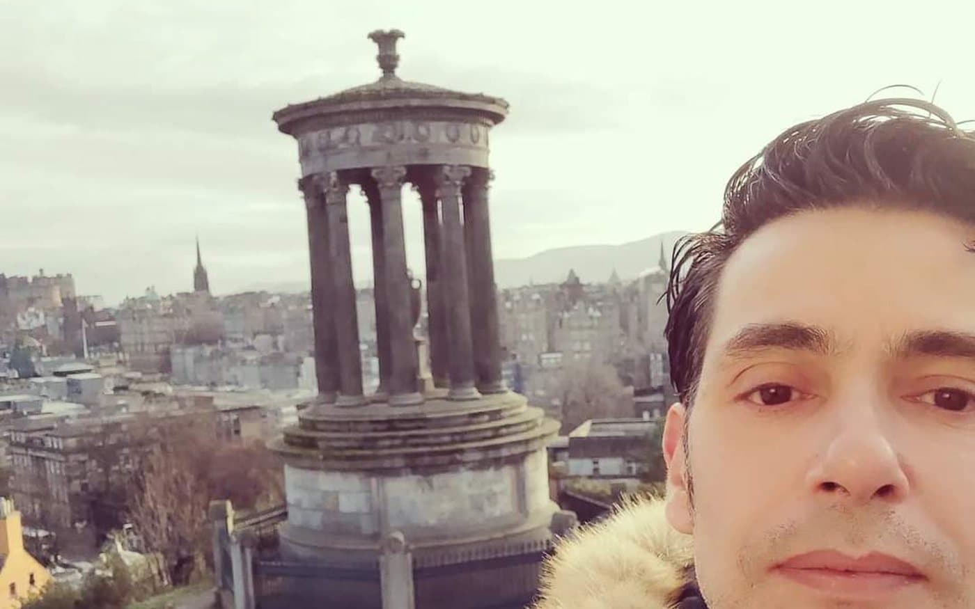 Diego Fresno on Calton Hill with the Dugald Stewart Monument and the Old Town skyline behind him