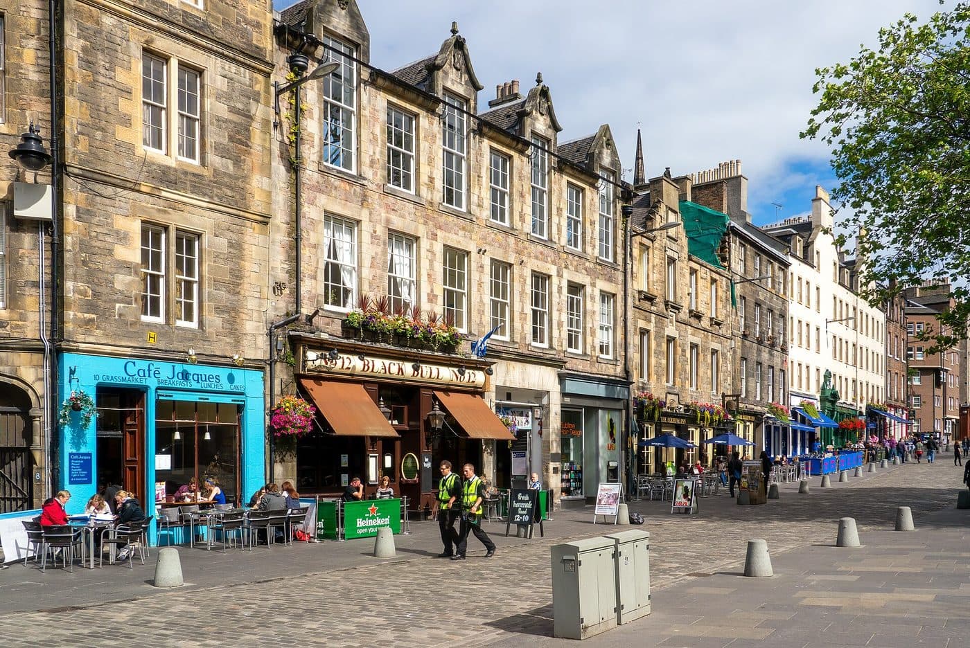 The south side of the Grassmarket in Edinburgh, with pub and café terraces, outdoor tables and the wide paved square in front