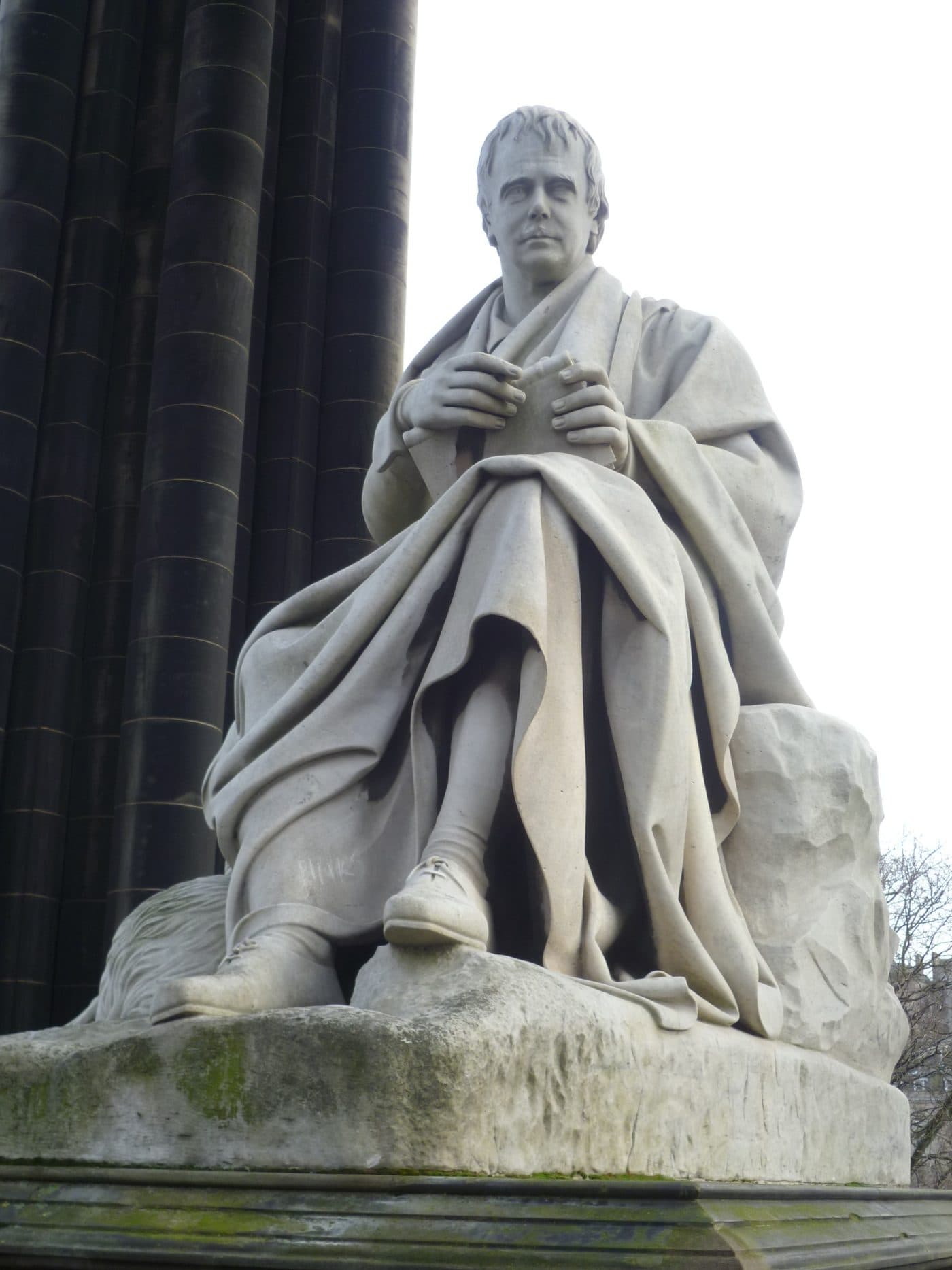 The white Carrara marble statue of Sir Walter Scott seated with his dog Maida beneath the Scott Monument